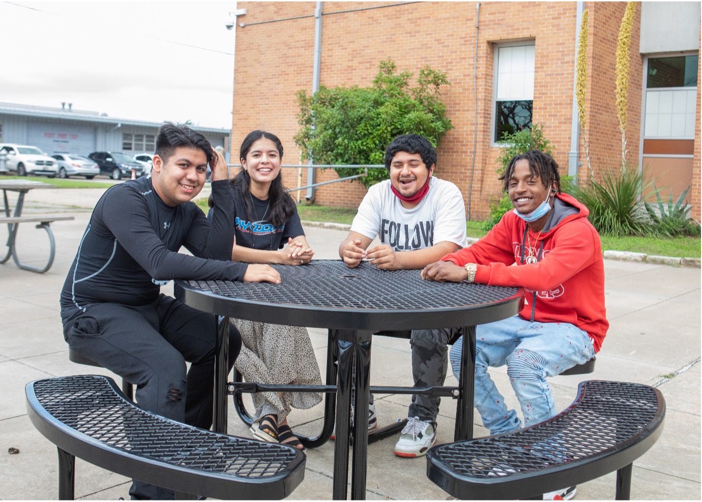 Students sitting around an outdoor table.