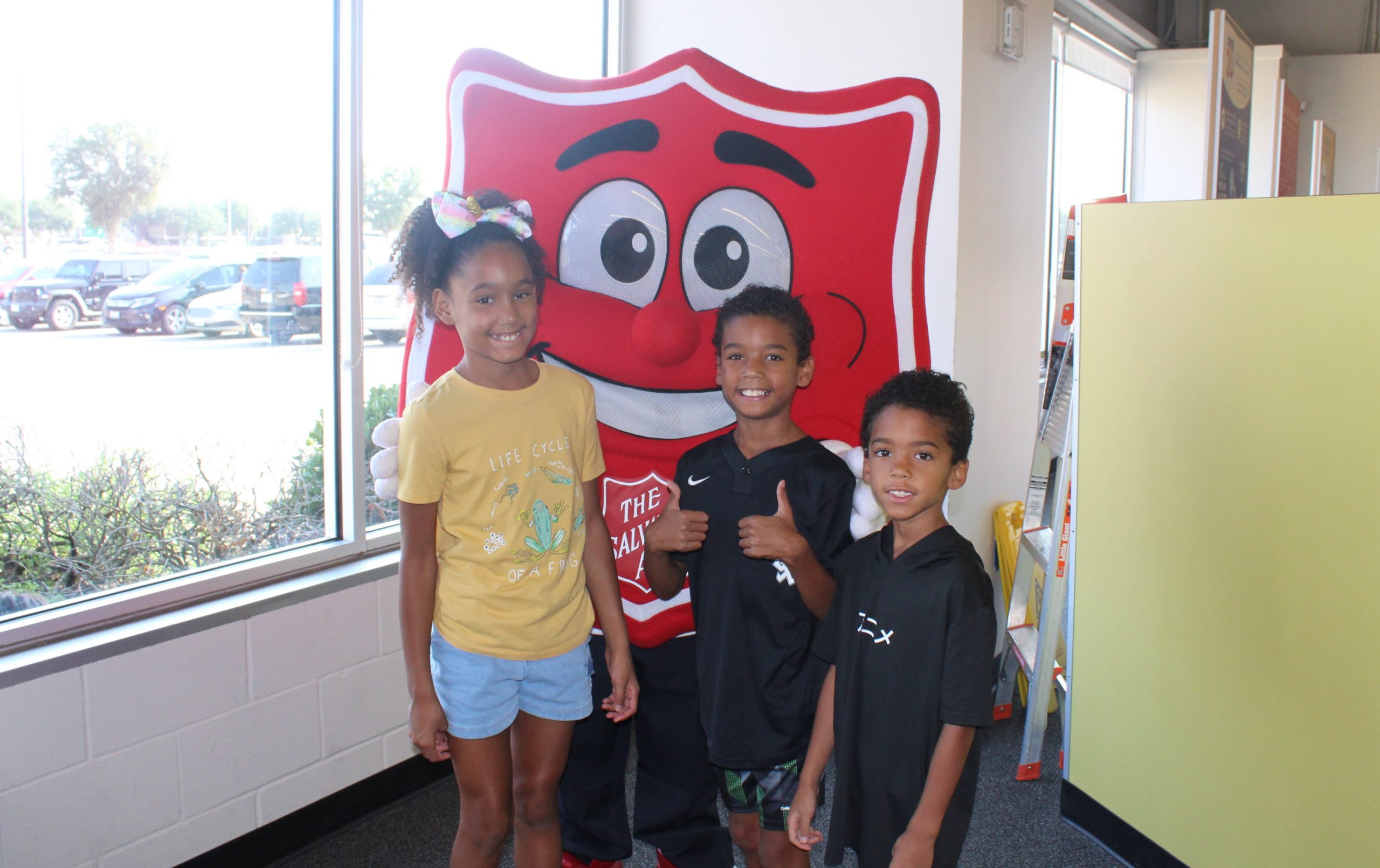 Three kids with Salvation Army symbol