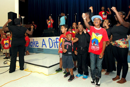 Kids cheering in front of a stage.